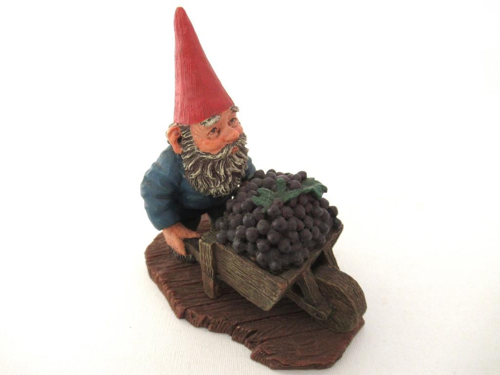UpperDutch:Gnome,Gnome figurine transporting grapes with a wheelbarrow 'Christian'. Classic gnomes series after a design by Rien Poortvliet.