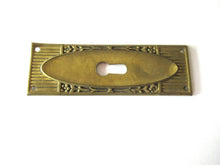 Escutcheon with flowers, brass keyhole cover.