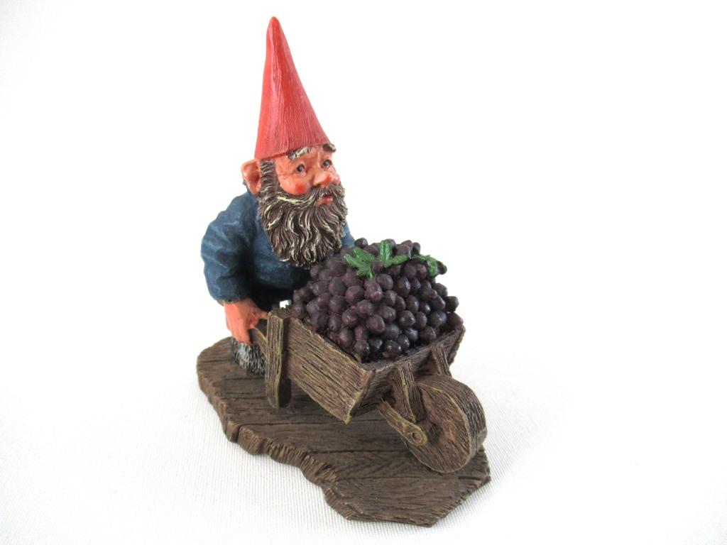 Gnome figurine transporting grapes with a wheelbarrow.  'Christian' Classic gnomes series after a design by Rien Poortvliet.