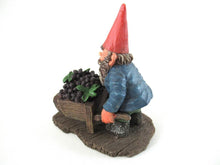 Gnome figurine transporting grapes with a wheelbarrow.  'Christian' Classic gnomes series after a design by Rien Poortvliet.