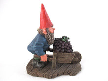 Gnome figurine transporting grapes with a wheelbarrow.  'Christian' Classic gnomes series after a design by Rien Poortvliet.