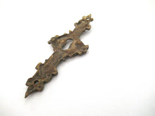 An Antique ornate brass keyhole cover. Ornamental escutcheon, cabinet hardware, furniture applique.