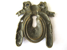 Escutcheon, bow, keyhole cover, Restoration hardware.