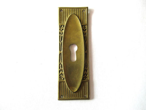 Escutcheon with flowers, brass keyhole cover.