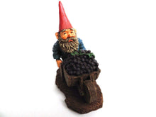 UpperDutch:Gnome,'Christian' Gnome figurine transporting grapes with a wheelbarrow.  Classic gnomes series after a design by Rien Poortvliet.