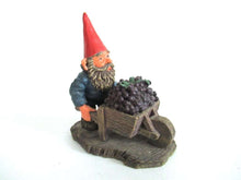 UpperDutch:,Designed by Rien Poortvliet. Gnome figurine transporting grapes with a wheelbarrow 'Christian'.  Classic gnomes series.