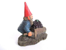 UpperDutch:,Designed by Rien Poortvliet. Gnome figurine transporting grapes with a wheelbarrow 'Christian'.  Classic gnomes series.