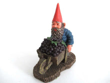 UpperDutch:,Gnome figurine transporting grapes with a wheelbarrow 'Christian'.  Classic gnomes series after a design by Rien Poortvliet.