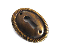 UpperDutch:Hooks and Hardware,1 (ONE) small Oval Stamped Keyhole cover, Antique brass escutcheon, key hole frame, plate.